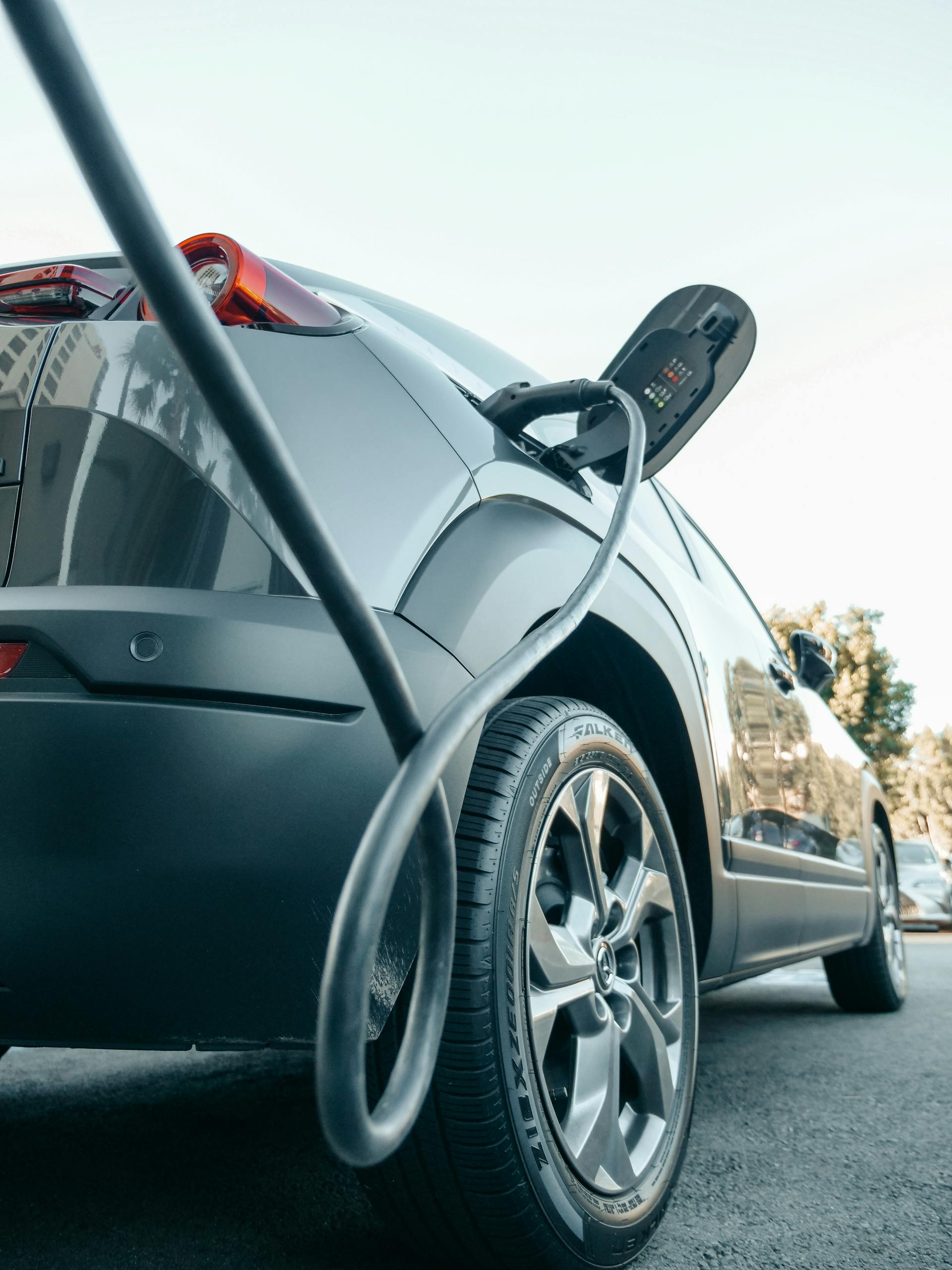 Close-up of an electric car charging at a modern charging station, showcasing clean energy technology.